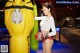 A woman in a white top and red boxing gloves standing next to a punching bag.