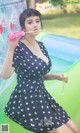 A woman in a black and white dress blowing bubbles.