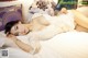 A woman laying on a bed in a white lingerie.